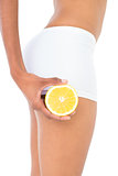 Close up of a fit woman carrying half an orange