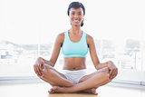 Smiling black haired woman doing yoga