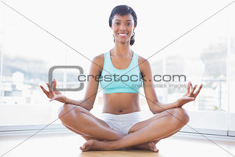Cheerful black haired woman doing yoga
