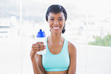 Happy fit woman holding a bottle of water