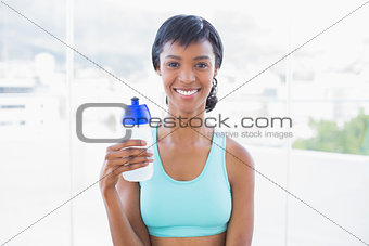 Happy fit woman holding a bottle of water