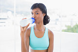 Pleased fit woman drinking a bottle of water