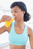 Meditative fit woman drinking a glass of orange juice