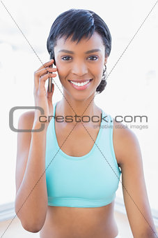 Joyful fit woman calling someone with her mobile phone