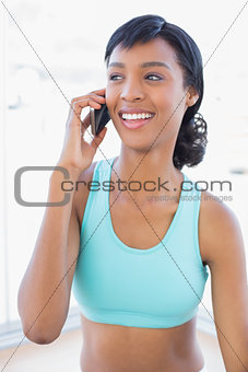 Laughing fit woman calling someone with her mobile phone