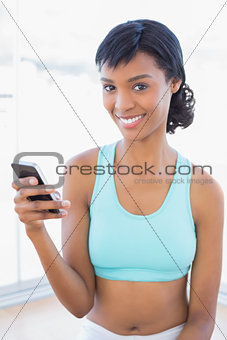 Content fit woman texting with her mobile phone