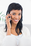 Seductive black haired woman in white clothes calling someone with her mobile phone