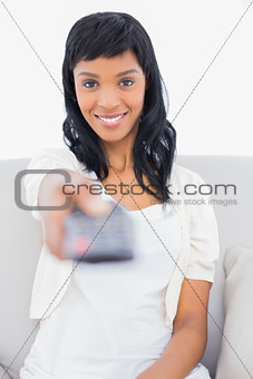 Cute black haired woman in white clothes changing tv channel
