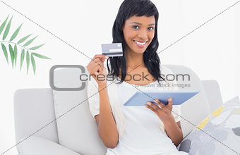 Stylish black haired woman buying online with her tablet pc