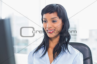 Smiling businesswoman looking at her computer