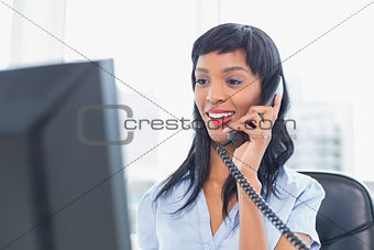 Pleased businesswoman answering the telephone