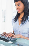 Smiling businesswoman typing on a keyboard