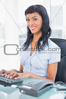 Cheerful businesswoman typing on a keyboard