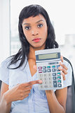 Stern businesswoman holding a calculator