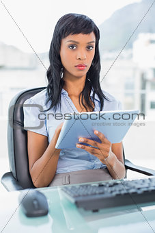 Stern businesswoman using a tablet pc