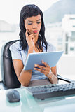Pensive businesswoman using a tablet pc