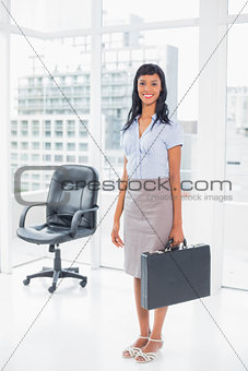 Pretty businesswoman holding a suitcase