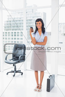 Happy businesswoman texting on her mobile phone