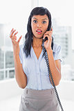 Angry businesswoman answering the phone