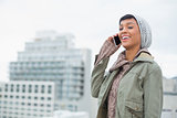 Laughing young model in winter clothes answering her phone