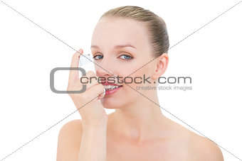 Natural pretty blonde model using an asthma inhaler