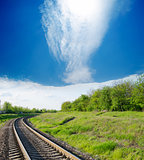 railway goes to horizon in green landscape
