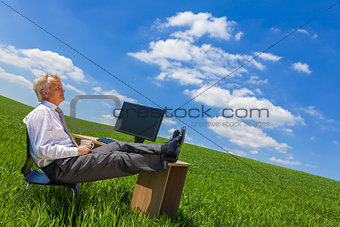 Businessman Relaxing Thinking At Desk in Green Field