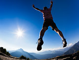 Man jumping in the sunshine against blue sky