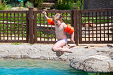 Little girl jumping into the pool