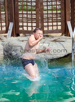 Boy jumps in the pool