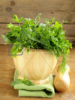 various herbs (basil, thyme, parsley, mint and dill) on wooden background