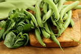 Fresh green beans and basil on the kitchen board