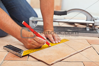 Laying ceramic floor tiles - man hands closeup