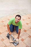 Man laying floor tiles - with copy space