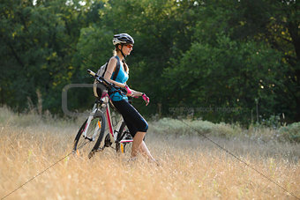 Young Attractive Woman Resting with Bike in the Beautiful Forest
