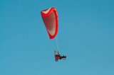 Paragliding flying over the clear blue sky 
