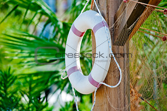 White life preserver hanging on a wooden post