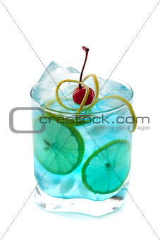 Blue alcohol cocktail with lemon slices and maraschino