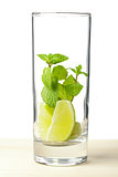 Mojito mix: lime, mint in glass on wood table