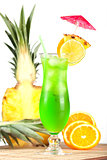 Green tropical cocktail with pineapple, orange and lime slices