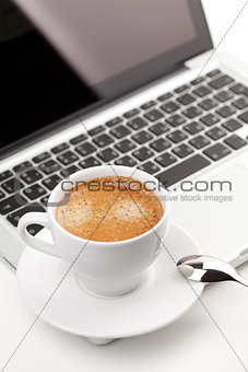 Cappuccino cup on laptop 