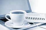 Cappuccino cup with laptop and newspaper. Toned