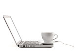 Cappuccino cup with spoon on laptop