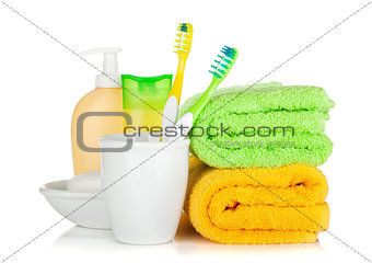 Two colorful toothbrushes, cosmetics bottles and towels