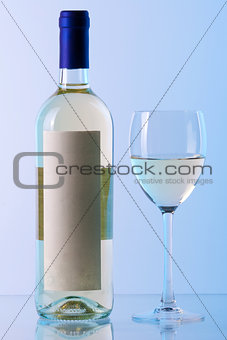 Bottle of white wine and wine glass in blue gamma