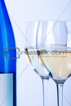Blue bottle of white wine and two wine glasses