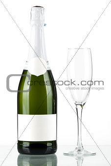 Bottle of champagne with blank label and with empty glass