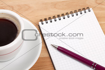 Espresso cup with blank notepad and pen