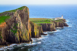 View of Neist Point lighthouse and rocky ocean coastline, Scotla