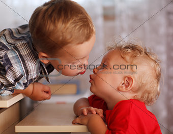 Cute siblings. Two little brothers are kissing.